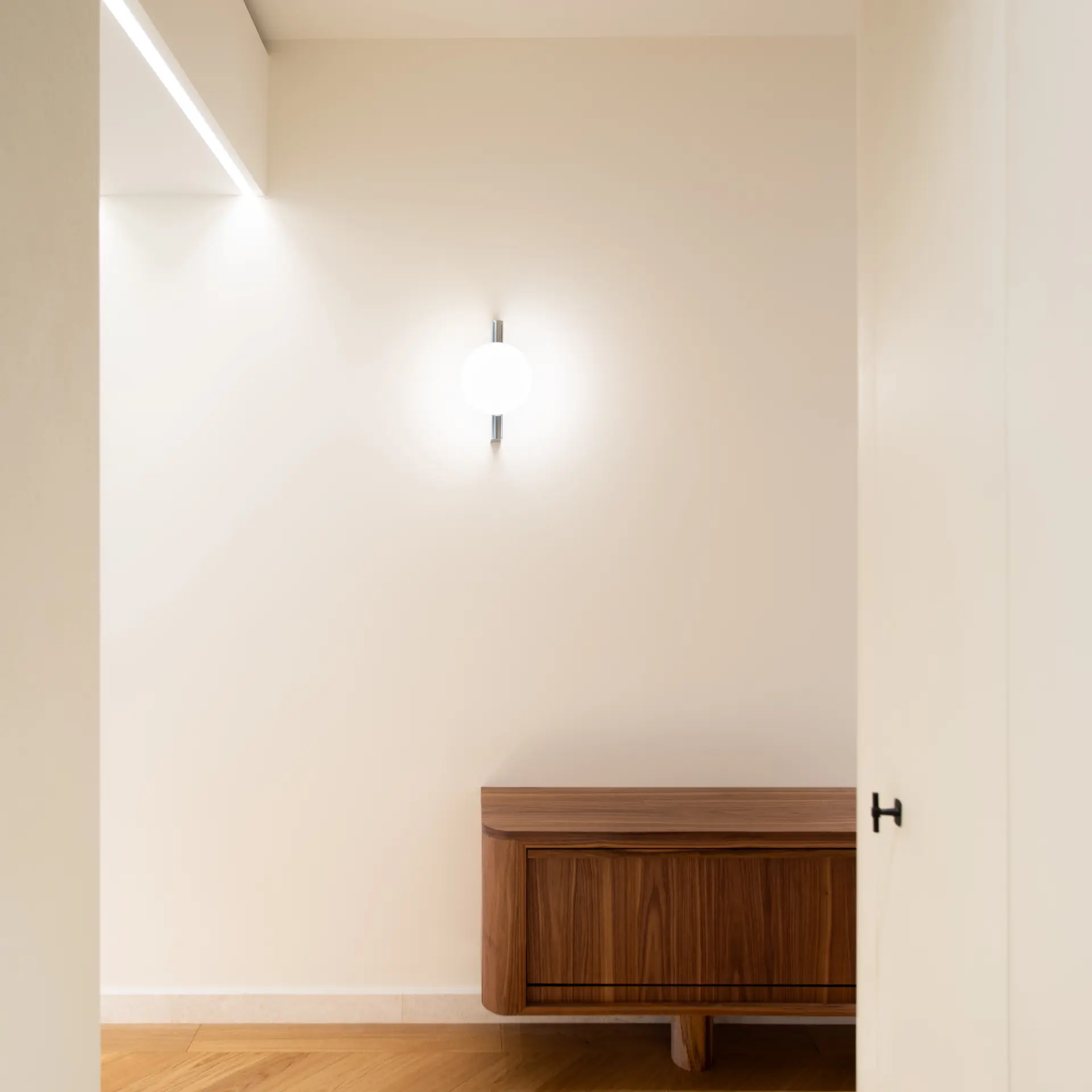 Pantofar din nuc sub o aplică globulară în holul apartamentului D402