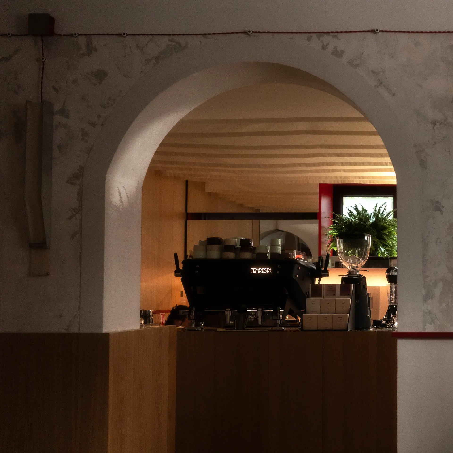 Espressorul și barul cafenelei văzute prin arcada demisolului